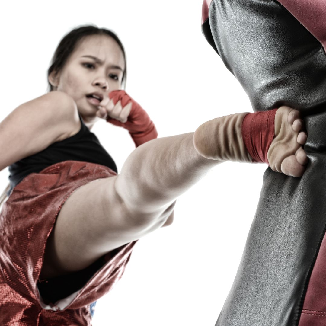 Women kicking a muay thai bag